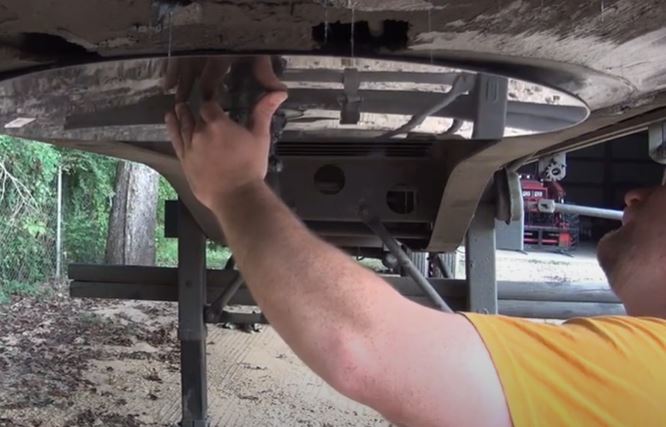 A guy is Installing the Fifth Wheel Lube Plate onto the Trailer's Hitch Receiver